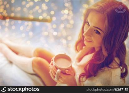 morning, leisure, christmas, winter and people concept - happy young woman with cup of coffee or cocoa in bed at home. happy woman with cup of cocoa in bed at home