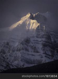 Morning light glows on a face of Mount Temple within Banff National Park during the winter.