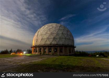 Morning light reflects on old abandoned soviet long range radar station Pamir, military unit with antennas in Carpathian mountains, Ukraine. Radar station geosphere on the starry sky background