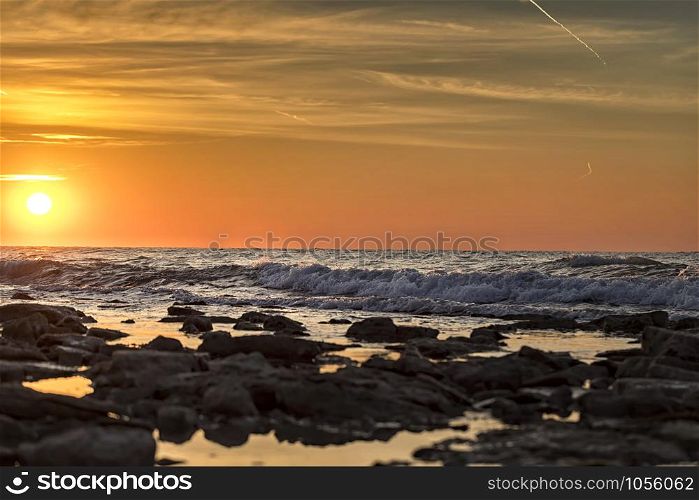 morning long exposure seascape with sun and stones on the water