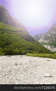 Morning mist in Italian Alps. View of the mountain dry riverbed in Italy at sunrise