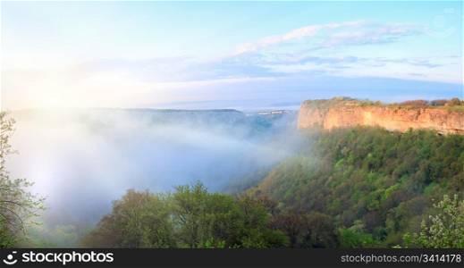Morning misty view from top of Mangup Kale - historic fortress and ancient cave settlement in Crimea (Ukraine) in sunshine rays. Two shots stitch image.