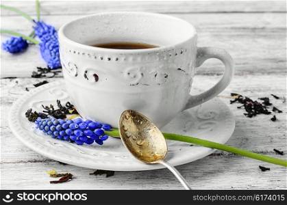 Morning mug of tea. Stylish ceramic tea cup and blossoming twigs hyacinth