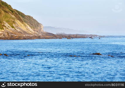 Morning ocean coast view from shore (near Saint-Jean-de-Luz, France, Bay of Biscay). Two fishermen are unrecognizable.