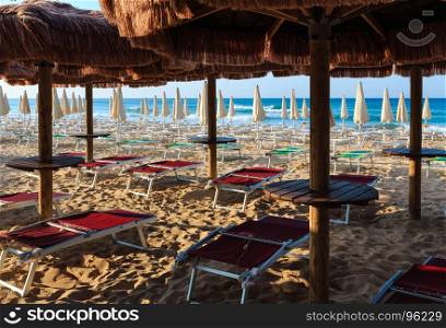 Morning paradise white sandy beach Maldives of Salento with sunshades and sunbeds (Pescoluse, Salento, Puglia, south Italy). The most beautiful sea sandy beach of Apulia.