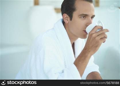 Morning portrait of handsome young man with cup of coffee