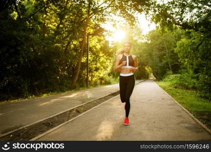 Morning run, woman on training in summer park. Female runner goes in for sports at sunny day, healthy lifestyle, jogger on outdoors workout. Morning run, woman on training in summer park