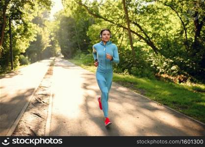 Morning run, woman on training in summer park. Female runner goes in for sports at sunny day, healthy lifestyle, jogger on outdoors. Morning run, woman on training in summer park