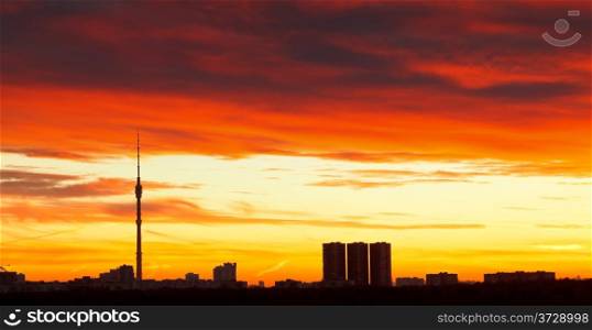 morning skyline with dramatic dark red sunrise sky over urban houses