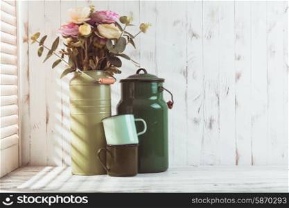 Morning still life with green utensils on shabby chic table and light from the blinds. Morning kitchen still life