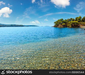 Morning summer Aegean Sea rocky coast landscape with pine trees on shore and beach, Sithonia (near Ag. Kiriaki), Halkidiki, Greece.