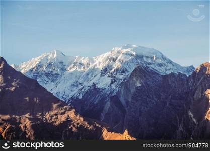 Morning sunlight shining at snow capped Rakaposhi mountain in Karakoram mountain range. Nagar valley, Gilgit Baltistan, Pakistan.