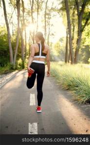 Morning training in park, woman prepares for running. Female runner goes in for sports at sunny day, healthy lifestyle, jogger on outdoors workout. Training in park, woman prepares for running