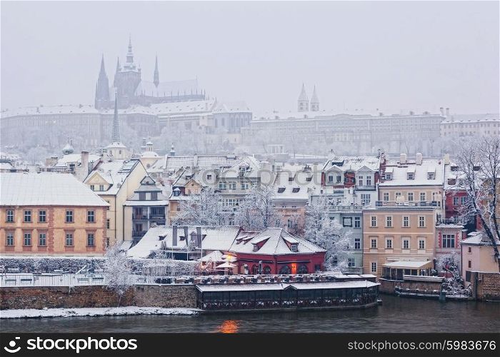 morning view from Charles bridge on snow Prague castle