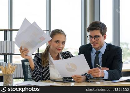 Morning work atmosphere In a modern office. Teen employees present annual profit and loss charts to colleagues. The man in the suit intended to read important data on paper.