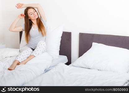 Mornings, chilling people concept. Attractive woman in the bed. Beautiful young lady has cosy pyjamas and long hair.