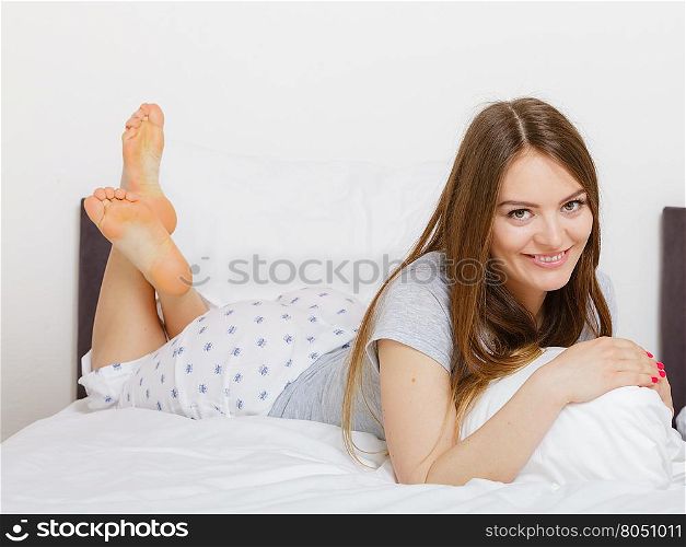 Mornings, chilling people concept. Beautiful woman lying on the bed. Attractive young lady wearing pyjamas.