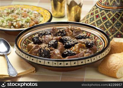 Moroccan dish with meat, plums ans sesameseeds close up