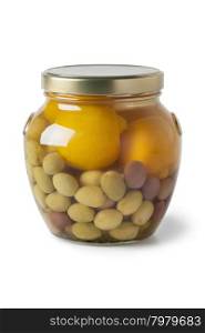 Moroccan glass jar with preserved olives and lemons on white background