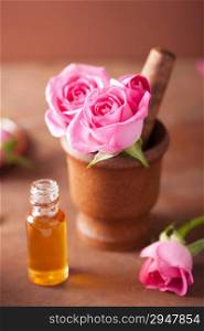 mortar with rose flowers and essential oil for aromatherapy and spa