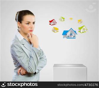 Mortgage concept. Image of young woman in suit looking at house model. Construction