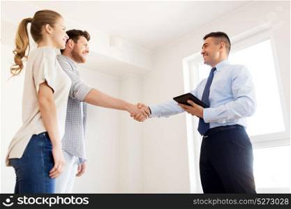 mortgage deal, people and real estate concept - happy couple and realtor with tablet pc computer shaking hands at new home. man and realtor shaking hands at new home