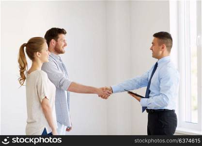 mortgage deal, people and real estate concept - happy couple and realtor with tablet pc computer shaking hands at new home. man and realtor shaking hands at new home