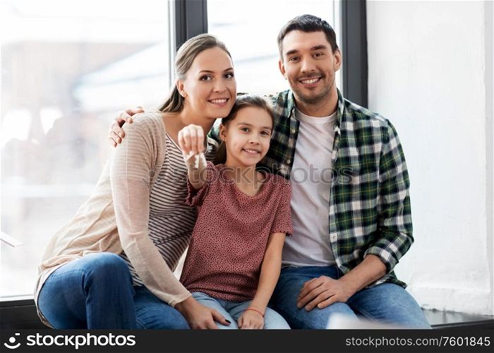 mortgage, family and real estate concept - happy mother, father and little daughter with house keys moving to new home. happy family with house keys moving to new home