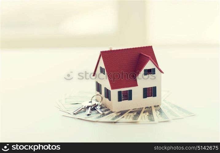 mortgage, investment, real estate and property concept - close up of home model, dollar money and house keys. close up of home model, money and house keys