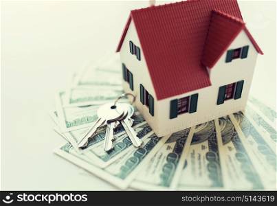 mortgage, investment, real estate and property concept - close up of home model, dollar money and house keys. close up of home model, money and house keys