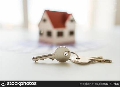 mortgage, investment, real estate and property concept - close up of home model, money and house keys