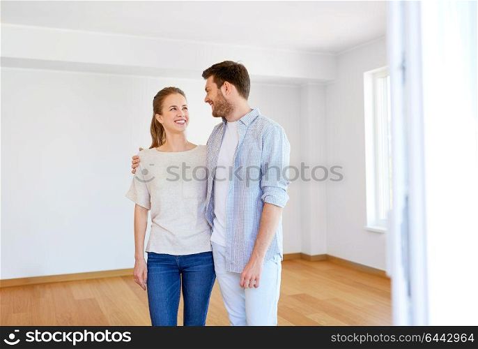 mortgage, moving, people and real estate concept - happy couple hugging at new home. happy couple hugging at new home