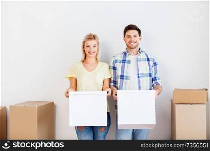 mortgage, moving, people and real estate concept - happy couple with cardboard boxes at new home. happy couple with boxes moving to new home