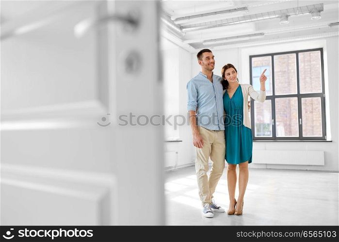 mortgage, people and real estate concept - happy couple hugging at new home. happy couple hugging at new home