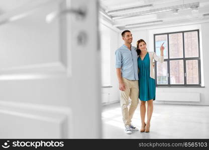 mortgage, people and real estate concept - happy couple hugging at new home. happy couple hugging at new home