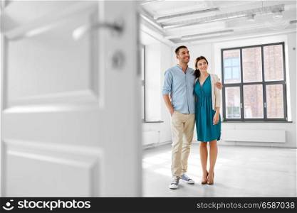 mortgage, people and real estate concept - happy couple hugging at new home. happy couple hugging at new home