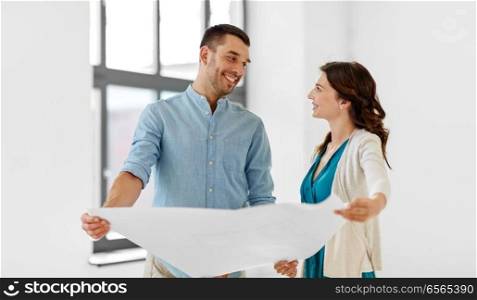 mortgage, people and real estate concept - happy couple with blueprint at to new home. happy couple with blueprint at to new home
