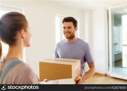 mortgage, people and real estate concept - happy couple with boxes moving to new home. happy couple with boxes moving to new home