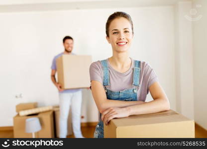 mortgage, people and real estate concept - happy couple with boxes moving to new home. happy couple with boxes moving to new home