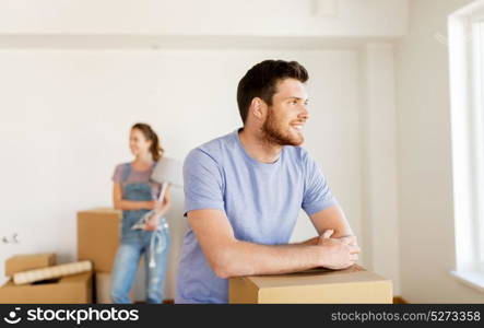 mortgage, people and real estate concept - happy couple with boxes moving to new home. happy couple with boxes moving to new home