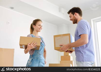 mortgage, people and real estate concept - happy couple with boxes moving to new home. happy couple with boxes moving to new home