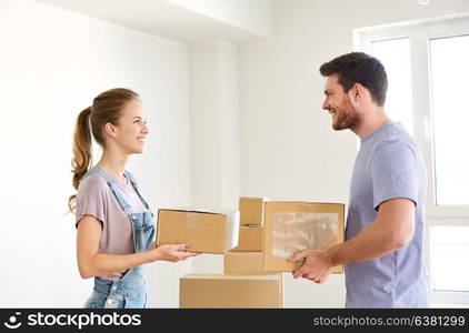 mortgage, people and real estate concept - happy couple with boxes moving to new home. happy couple with boxes moving to new home