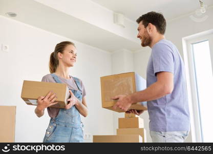 mortgage, people and real estate concept - happy couple with boxes moving to new home. happy couple with boxes moving to new home