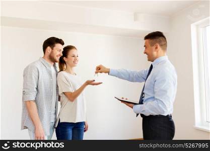 mortgage, people and real estate concept - realtor giving keys to new apartment or home to happy couple. realtor giving keys from new home to happy couple