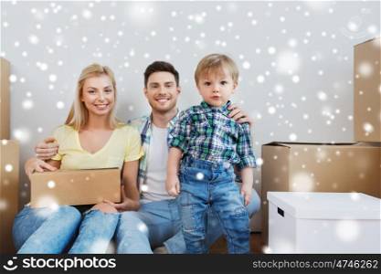 mortgage, people, housing and real estate concept - happy family with boxes moving to new home over snow