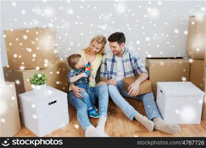 mortgage, people, housing and real estate concept - happy family with boxes moving to new home over snow