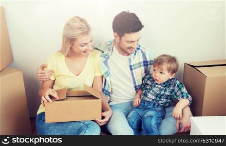mortgage, people, housing and real estate concept - happy family with boxes moving to new home. happy family with boxes moving to new home