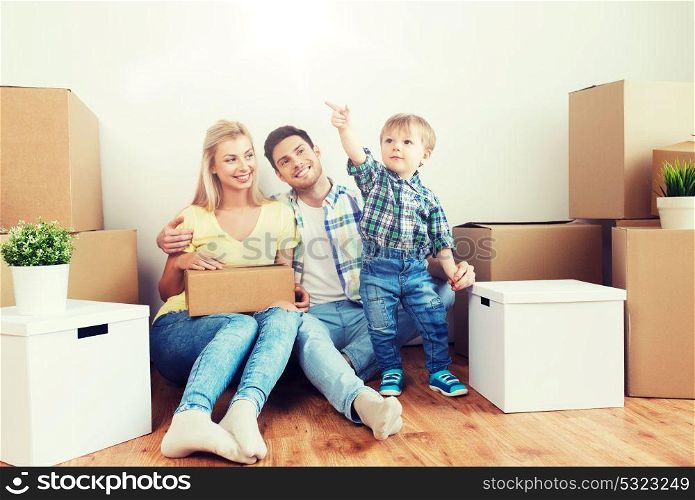 mortgage, people, housing and real estate concept - happy family with boxes moving to new home. happy family with boxes moving to new home