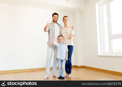 mortgage, people, housing and real estate concept - happy family with child moving to new home and showing thumbs up. happy family with child moving to new home