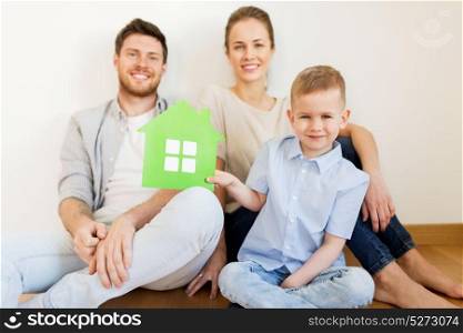 mortgage, people, housing and real estate concept - happy family with green paper house moving to new home. happy family with green house moving to new home